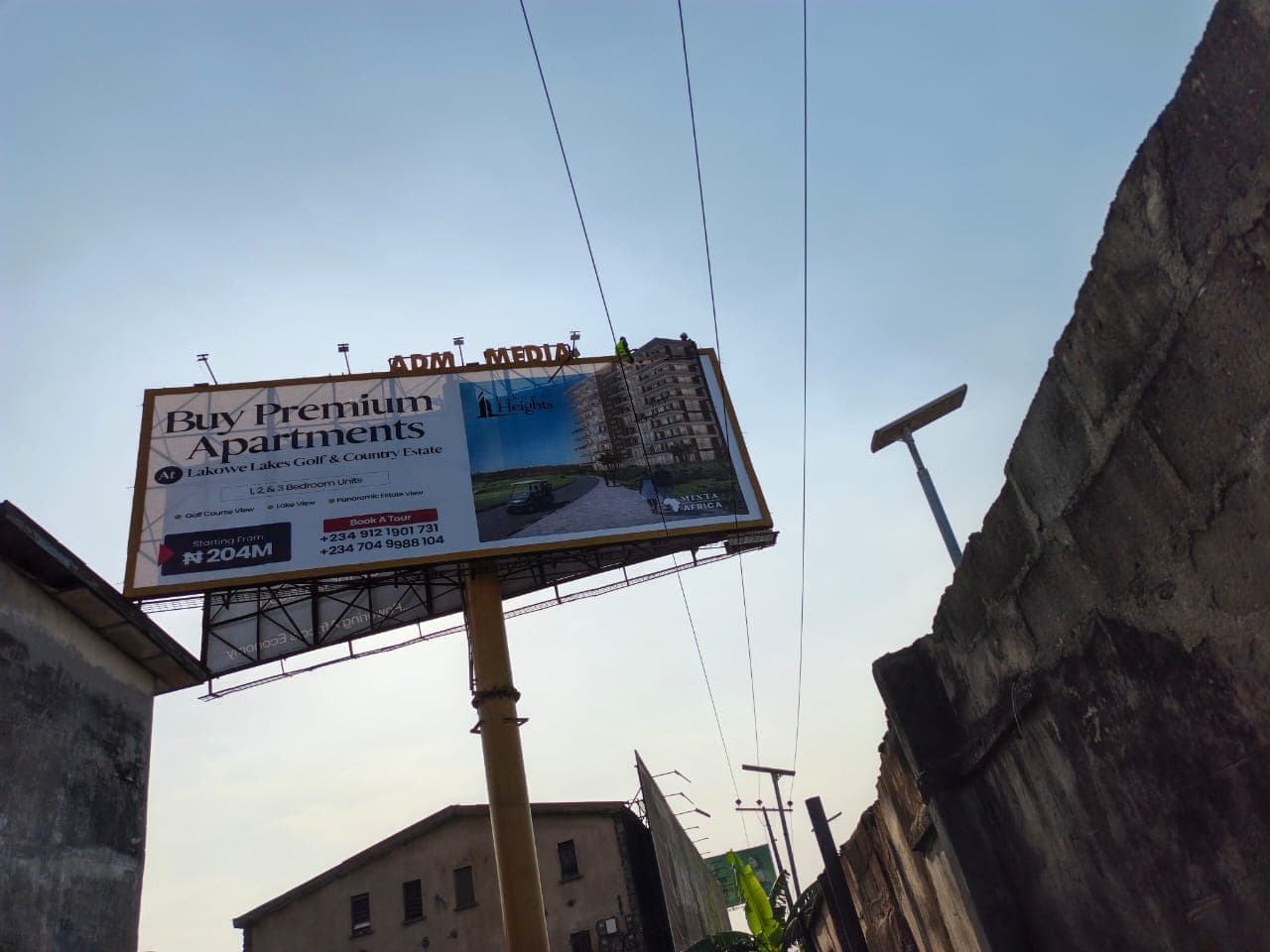 Lakowe Heights uni-pole advertising premium apartments, with riggers working on the deck above the face.