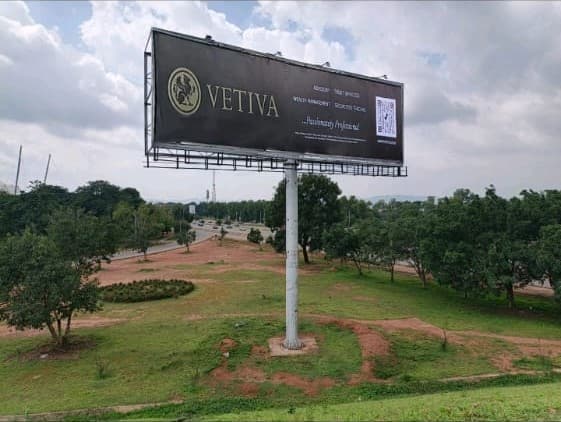 Vetiva uni-pole standing in open parkland on an Abuja approach road.