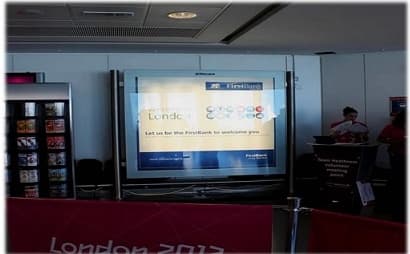 First Bank “Let us be the FirstBank to welcome you” screen at a Heathrow London 2012 volunteer desk.